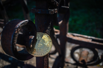 Golden bit coin on rusty fence