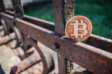 Wooden Bit Coin on rusty abstract fence