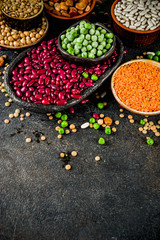 Various assortment of legumes - beans, soy beans, chickpeas, lentils, green peas. Healthy eating concept. Vegetable proteins. White marble background copy space top view