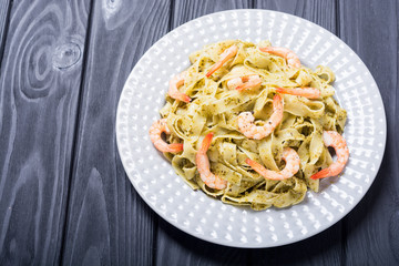 Pasta tagliatelle with sauce pesto and shrimps . Italian food background
