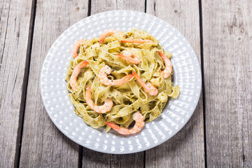 Pasta tagliatelle with sauce pesto and shrimps . Italian food background