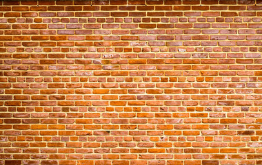 Red orange brick wall with yellow cement between the bricks detail as surface texture background.