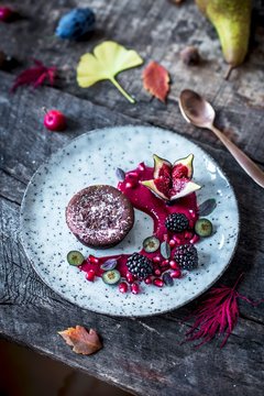 Chocolate cake with a liquid egg liqueur centre, raspberry sauce and autumn fruits