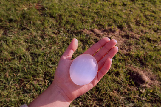 In der Handfl&auml;che Heilstein Selenit in Form von Seife