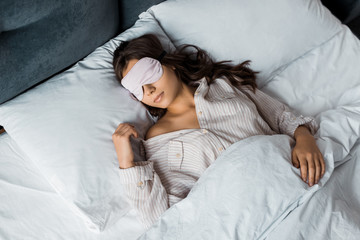 beautiful young woman sleeping in eye mask in bed