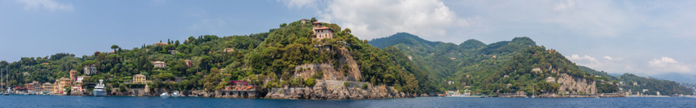 Panoramic view encompassing the entrance to Portofino harbour and the neighbouring town of Paraggi, Ligurian coast, Italy