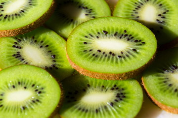 Sliced green fresh kiwi fruit pieces lying on table, flat lay view, healthy diet