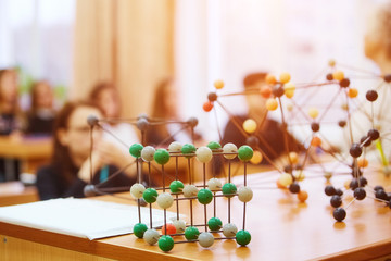 School children in a science class with a molecular model. Background image with soft focus....