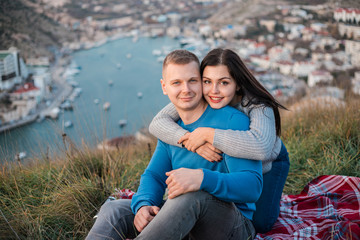 Happy couple seating outdoor near Black sea.