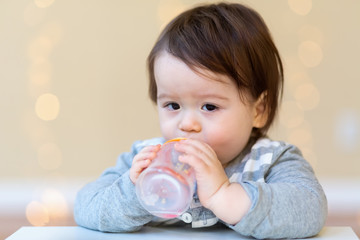 Toddler boy drinking juice in his house