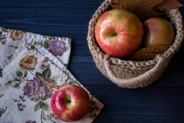 Red apples in a basket on a table.