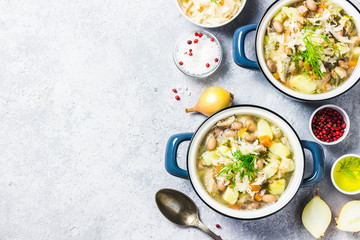 Sauerkraut red bean meat soup in pots. Top view, space for text.