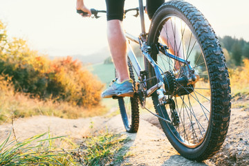 Naklejka premium Mountain biker ride down from hill. Close up wheel image