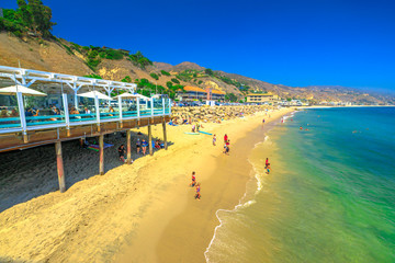 Obraz premium Malibu, Kalifornia, Stany Zjednoczone - 7 sierpnia 2018: malowniczy nadmorski krajobraz z górami Santa Monica, farmą Malibu i turkusowym morzem popularnej plaży Carbon lub plaży miliardera dla domów VIP.