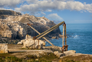 Old disused wooden crane used to move Portland stone against coastal background taken in Portland,...