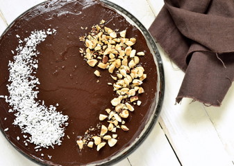 Chocolate-beet cake, decorated with hazelnut and coconut chips, top view 