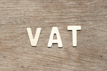 Alphabet letter in word VAT (Abberviation of Value added tax) on wood background