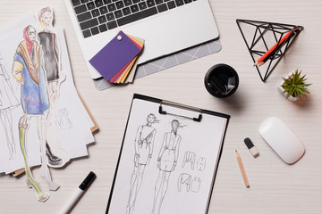 office desk with laptop, sketches and art supplies, flat lay