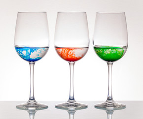 Three colored glasses on white background