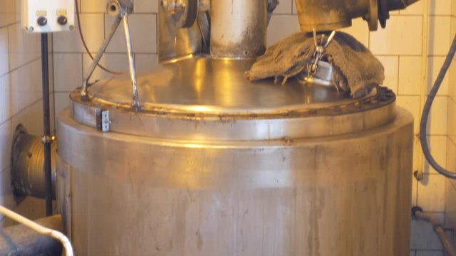 Growing distillery for the production of plum brandy by firing in a gas boiler, alembic pot still during process of distillation flow fresh plum brandy, bottles plum liquor slivovitz traditional czech