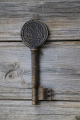 Antique key with the figure of arabic calligraphy on vintage wooden.