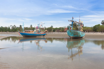 Wooden fishing boat on the  low tide beach