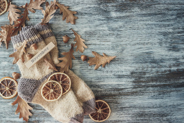 Pair of woolen socks and different dry decorations, wooden background