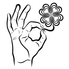 Hand holds clover with four leaves, ok sign and heart