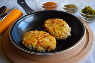 Delicious fried cutlets with spices in a frying pan.