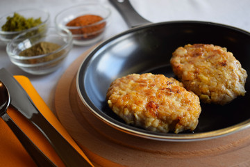 Delicious fried cutlets with spices in a frying pan.