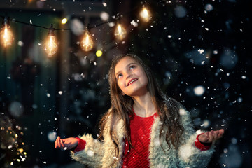 joyful fun of a young girl in a winter and snowy evening