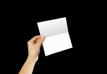 Hand holding blank brochure booklet in the hand. Isolated on black background. Man show offset...