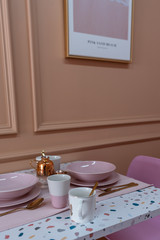 Dining corner with terrazzo top table and baby pink chair and decoration prop on the table with old rose painted wall on the background / interior design concept / studio shot