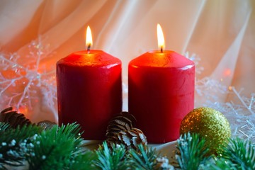 Christmas candles and green twigs on the background of lights.