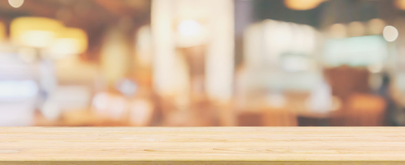 Wood table top with Restaurant cafe or coffee shop interior with people abstract defocused blur background