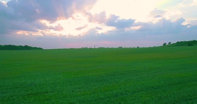 green field at sunset aerial 4k 50p move backward