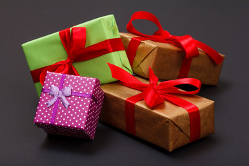 Gift boxes tied with ribbons on black background