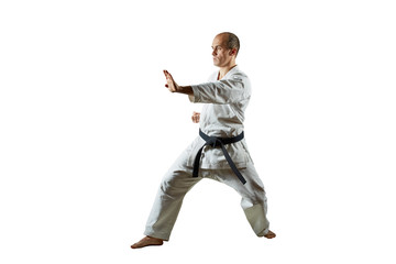 Athlete trains karate exercises on white isolated background