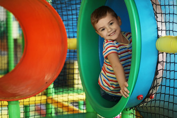 Cute little child playing at indoor amusement park