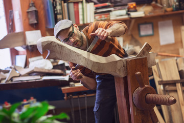 Carpenter working on wooden forcola for venetian gondola