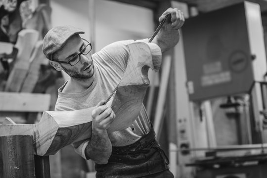 Carpenter working on wooden forcola for venetian gondola