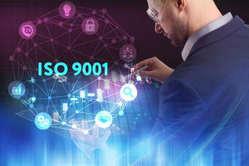 The concept of business, technology, the Internet and the network. A young entrepreneur working on a virtual screen of the future and sees the inscription: ISO 9001