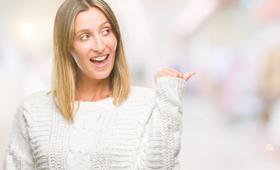 Young beautiful woman wearing winter sweater over isolated background smiling with happy face looking and pointing to the side with thumb up.