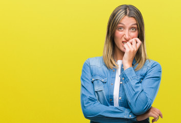 Young beautiful woman over isolated background looking stressed and nervous with hands on mouth biting nails. Anxiety problem.