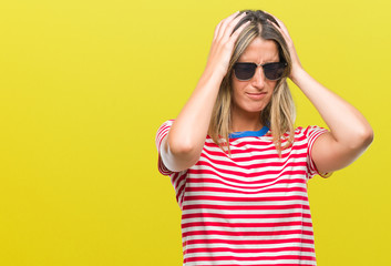 Young beautiful woman wearing sunglasses over isolated background suffering from headache desperate and stressed because pain and migraine. Hands on head.
