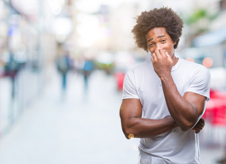 Afro american man over isolated background looking stressed and nervous with hands on mouth biting nails. Anxiety problem.