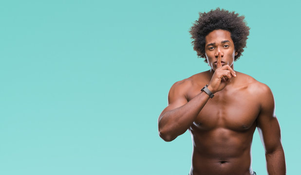 Afro american shirtless man showing nude body over isolated background asking to be quiet with finger on lips. Silence and secret concept.