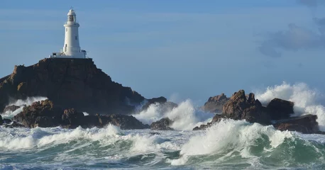 Tuinposter Vuurtoren La Corbiere lighthouse, Jersey, U.K.  Coastal landmark in dramatic weather.