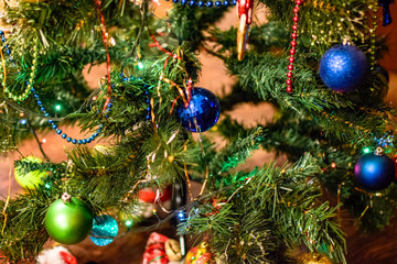 Tinsel and toys, balls and other decorations on the Christmas Christmas tree standing in the open air. Decorations New Year tree.