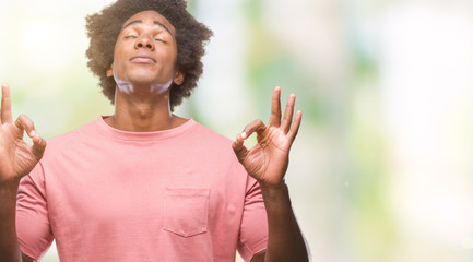 Afro american man over isolated background relax and smiling with eyes closed doing meditation gesture with fingers. Yoga concept.